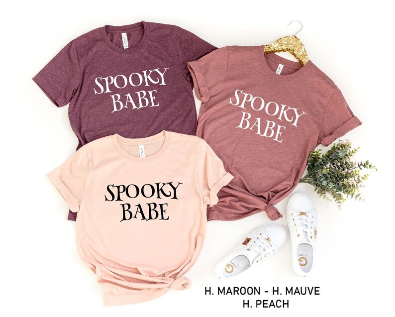 May include: Three t-shirts with the text "Spooky Babe" in different colors: maroon, mauve, and peach.