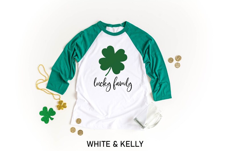 May include: White and green baseball tee shirt with a shamrock and the text "lucky family".