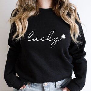 May include: Black sweatshirt with white text that says "lucky" with a white shamrock.