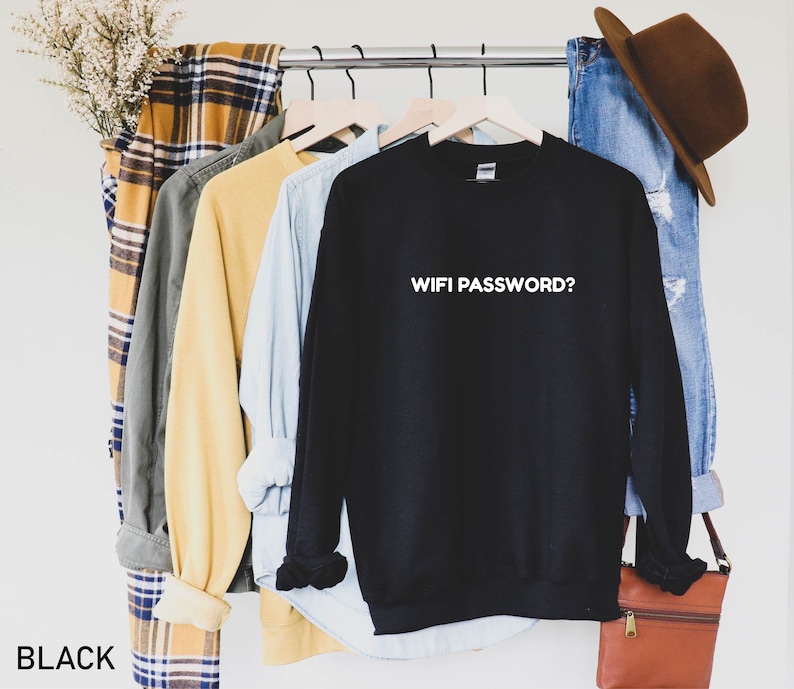 K&ouml;nnte beinhalten: Schwarzer Pullover mit dem Text "WIFI PASSWORD?" in wei&szlig;en Buchstaben. Der Pullover h&auml;ngt an einem Kleiderst&auml;nder mit anderer Kleidung.
