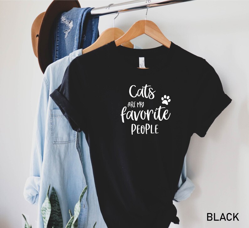 May include: Black t-shirt with white text that reads "Cats are my favorite people" and a white paw print.