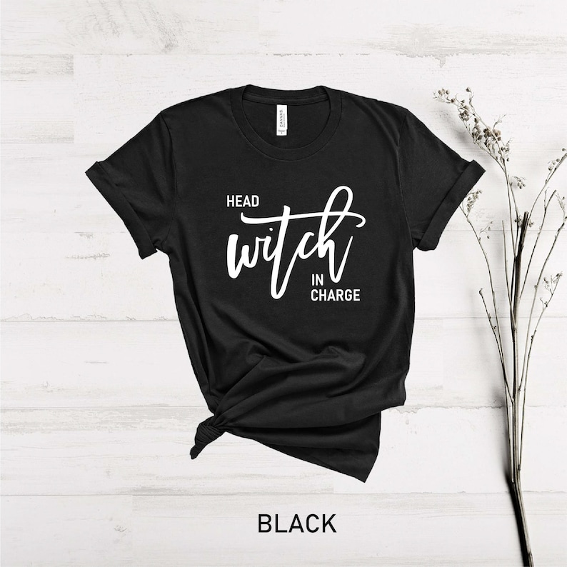May include: Black t-shirt with white text that reads "Head Witch in Charge".