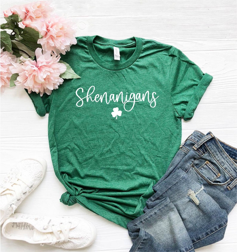 May include: Green t-shirt with white text that says "Shenanigans" and a shamrock.