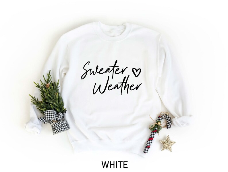 May include: White sweatshirt with the text "Sweater Weather" and a small heart symbol.