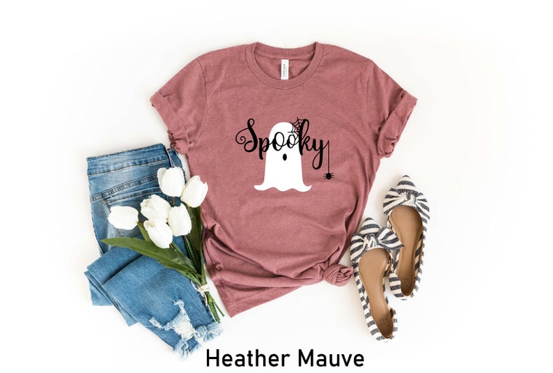 May include: Heather mauve t-shirt with a white ghost graphic and the text "Spooky" in black. The ghost has a spider web on its head and a spider hanging from a web.