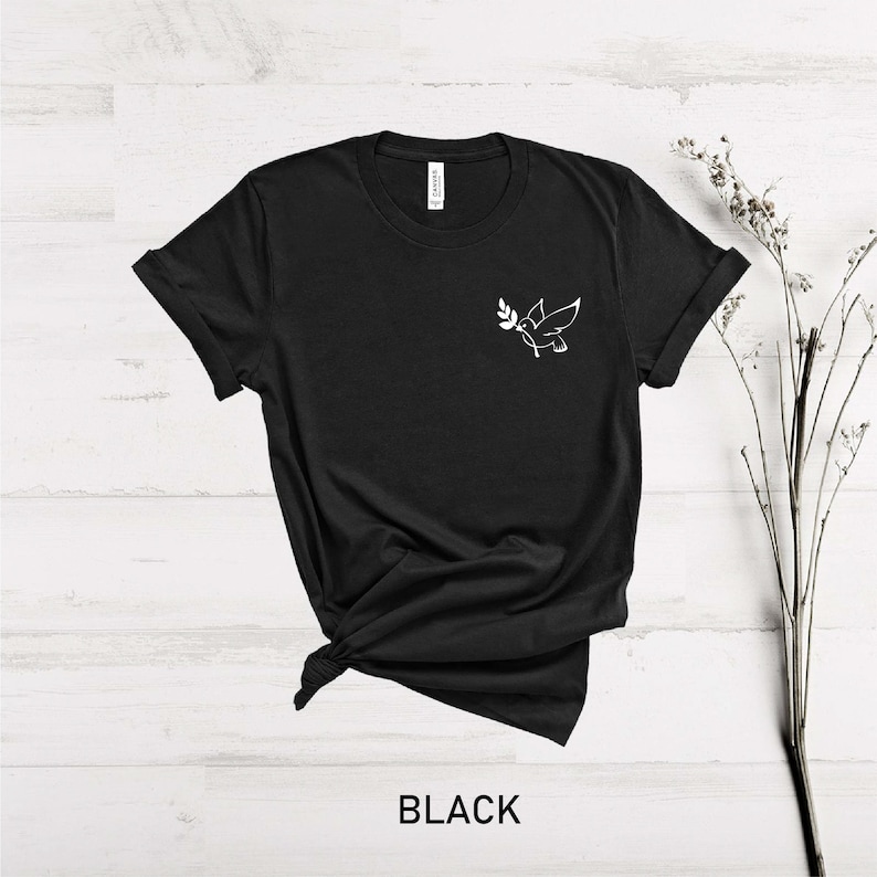 May include: Black t-shirt with a white outline of a dove carrying an olive branch on the left chest.