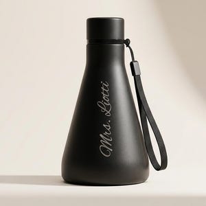 Peut inclure: Une bouteille d'eau noire mate avec une base large et un goulot étroit, dotée d'un bouchon à vis et d'une dragonne noire. Le texte Mrs. Liotti est gravé en écriture cursive blanche sur le devant de la bouteille, qui a une finition lisse.