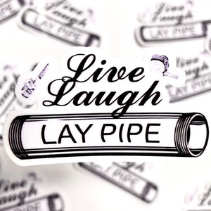 May include: A white sticker with black text that reads "Live Laugh Lay Pipe". The sticker features a stylised image of a pipe.