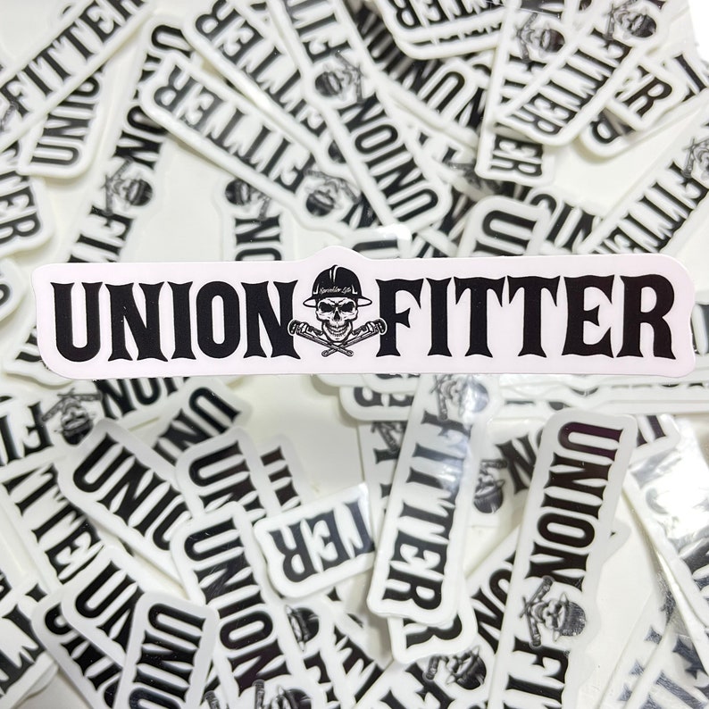 Puede incluir: Primer plano de una pila de pegatinas blancas con texto negro que dice "Union Fitter". Las pegatinas muestran una calavera con un casco y sosteniendo llaves inglesas cruzadas.