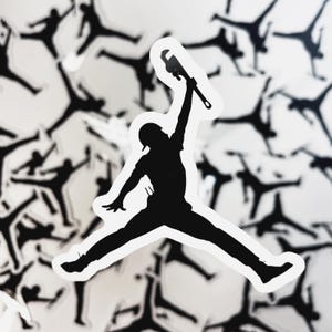 May include: A black die-cut sticker featuring a silhouette of a person in a jumping pose, wearing a cap and holding a pipe wrench high in one hand. The design is set against a background of multiple identical stickers in a repeating pattern.