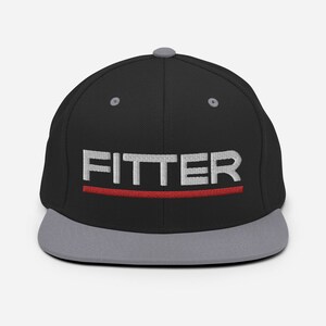May include: A black and gray fitted baseball cap with a red stripe and the word "FITTER" embroidered in white.