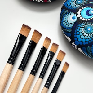 May include: Set of six paint brushes with black handles and wooden shafts. The brushes have a flat, angled shape and are arranged in order of size, with the largest brush at the top and the smallest brush at the bottom.