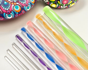 Può includere: Una collezione di bastoncini per mescolare in acrilico trasparente con un design a spirale, nei toni del viola, blu, rosa, arancione e verde. Due pietre decorative dipinte a mano con intricati motivi mandala.