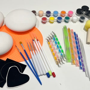 Könnte beinhalten: Ein Bastelset zum Malen und Dekorieren enthält eine Vielzahl von Werkzeugen wie Pinsel, Modellierwerkzeuge, Schwämme und Farbe. Das Set enthält auch eine Vielzahl von leeren Formen, darunter Herzen, Kreise und Ovale, die bemalt und dekoriert werden können.