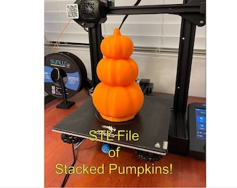 May include: A 3D printed stack of orange pumpkins on a black print bed of a 3D printer. The text "STL File of Stacked Pumpkins!" is below the print bed.