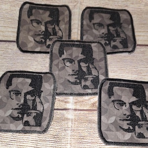 May include: Five black and white iron-on patches featuring a person wearing glasses and a patterned background. The patches are square and have a black border.