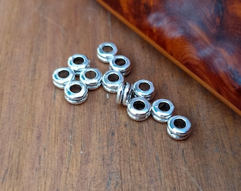 10 Spacer-Perlen aus antiksilbernem Metall.
