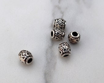 5 Tibetan style barrel-shaped spacer beads in silver-plated metal.