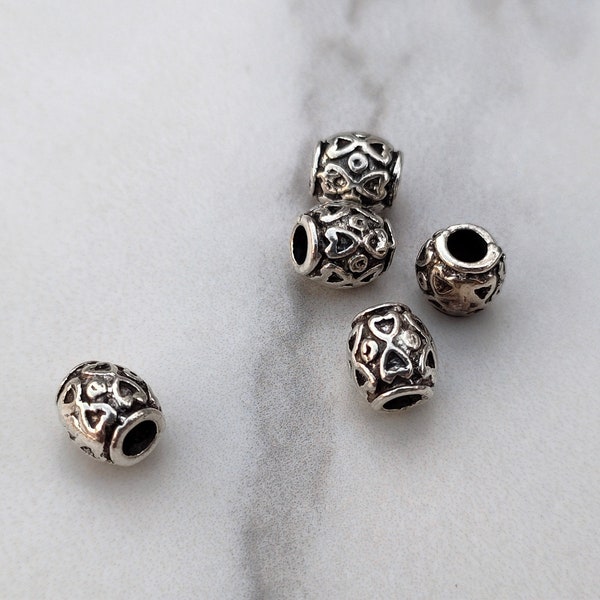 5 perles intercalaires de forme tonneaux style tibétain en métal argenté.