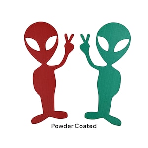 May include: Two alien figures with raised hands in a peace sign gesture. The alien on the left is red and the alien on the right is green. The text "Powder Coated" is below the figures.