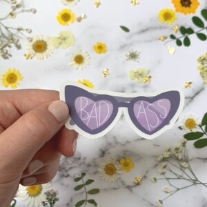 Bad Ass Gafas de Sol Pegatina diseñada por Lily Lewis. Pegatinas perfectas para portátiles, botellas de agua o relleno de medias. Garabateado en Miel.