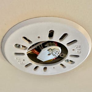 May include: White plastic electrical box with a round opening and a white electrical connector in the center. The box has the text "ECC" printed on it.