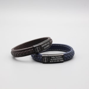 May include: Two leather bracelets with black metal medical alert tags. The top bracelet is brown with the text "MEDICAL ALERT". The bottom bracelet is blue with the text "John Sanders ALZHEIMERS ICE: 123.456.7890".