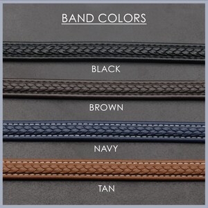 May include: Four different colored watch bands: black, brown, navy, and tan. The bands are all braided and have a stitched edge.