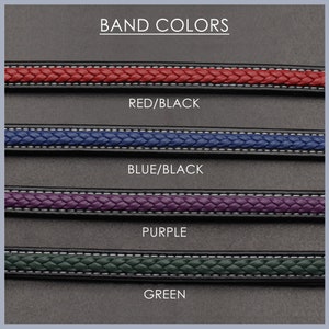 May include: Four different watch band colours: red/black, blue/black, purple, and green. The bands are braided and have a black backing.