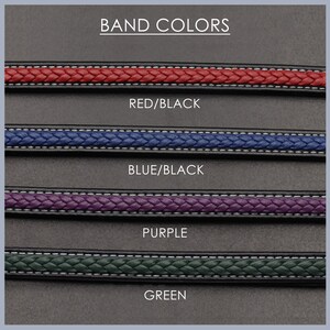 May include: Four different watch band colors: red/black, blue/black, purple, and green. The bands are braided and have a black backing.