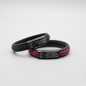 May include: Two black leather bracelets with stainless steel medical alert tags. The top bracelet has the text "YOUR MEDICAL INFO HERE" and the bottom bracelet has the text "TOM SMITH TYPE 1 DIABETIC ICE: 513-452-6789".