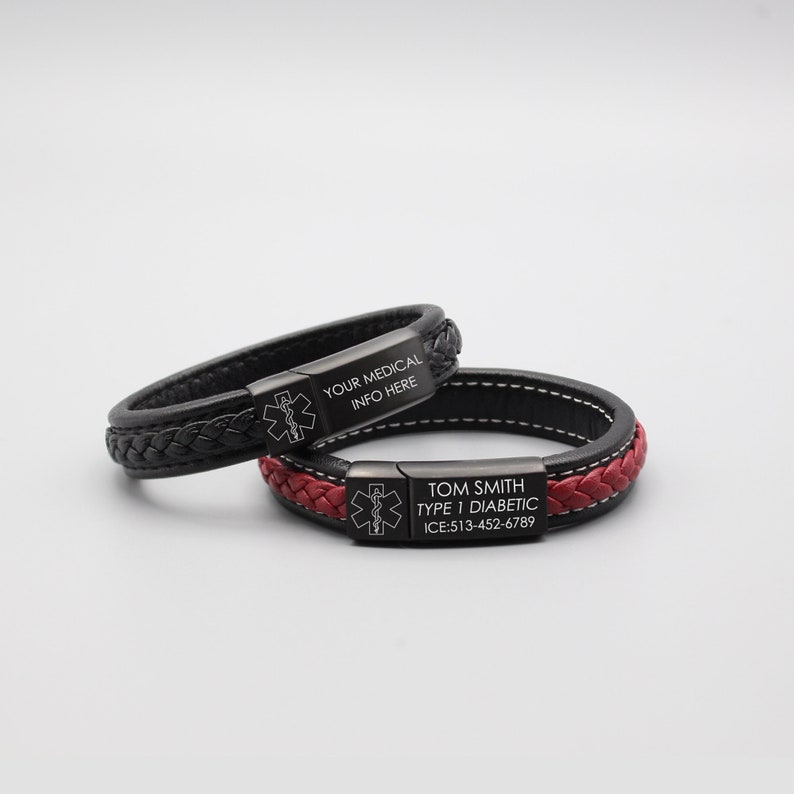 May include: Two black leather bracelets with stainless steel medical alert tags. The top bracelet has the text "YOUR MEDICAL INFO HERE" and the bottom bracelet has the text "TOM SMITH TYPE 1 DIABETIC ICE: 513-452-6789".