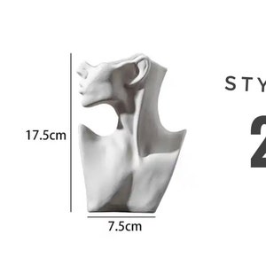 May include: White ceramic bust of a woman's neck and shoulders, used as a display stand for necklaces. The bust is 7.5 inches wide and 17.5 inches tall.  STYLE 2