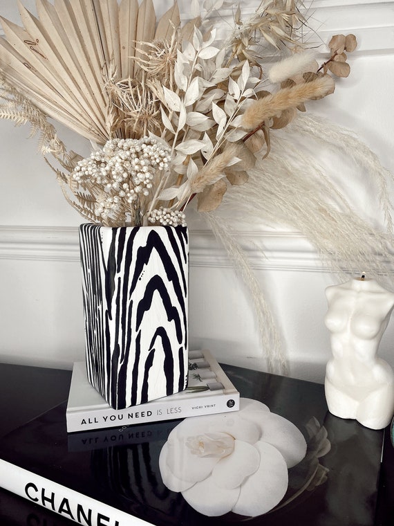Elegant Black and White Vases with Stunning White Flowers on a Black Mantle