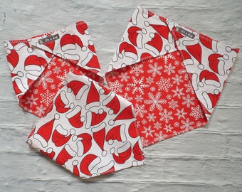 Bandana Hundehalstuch in rot und weiß mit Weihnachtsmützen und Schneeflocken. Verschiedene Größen und Formen. Beidseits zu tragen.