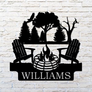May include: Black metal silhouette of two chairs facing a campfire with trees and birds in the background. The text "WILLIAMS" is below the image.