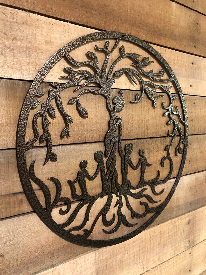 May include: A metal wall art sculpture of a tree of life with a textured, dark brown finish. The tree has a thick trunk and branches with leaves. Five figures are holding hands around the base of the tree.