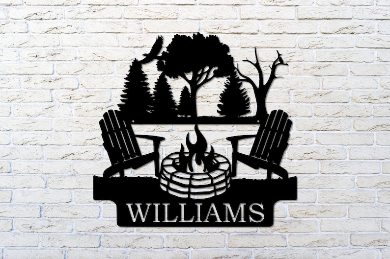 May include: Black metal silhouette of two chairs facing a campfire with trees and birds in the background. The text "WILLIAMS" is below the image.