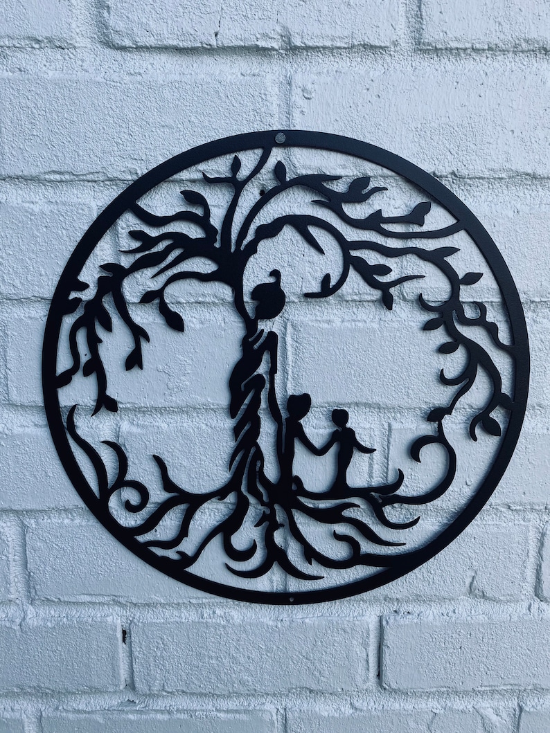 May include: Black metal wall art featuring a stylised tree of life with a bird perched on a branch and two figures standing at the base of the tree.