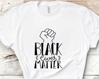 May include: White t-shirt with a black fist raised in the air and the text "Black Lives Matter" printed on the front.