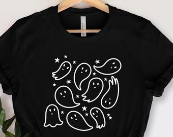 May include: Black t-shirt with a white design of multiple smiling ghosts and stars.