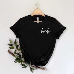 May include: Black t-shirt with the word "bride" written in white script on the front.