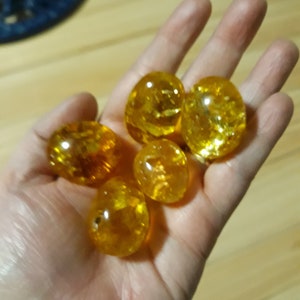 May include: Six round, translucent, amber-coloured glass beads.