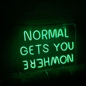 K&ouml;nnte beinhalten: Gr&uuml;nes Neon-Schild mit dem Text "NORMAL GETS YOU NOWHERE".