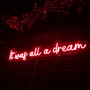 K&ouml;nnte beinhalten: Rotes Neon-Schild mit dem Text "It was all a dream" in einer kursivschrift.