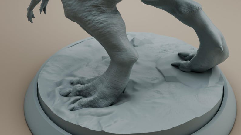 Puede incluir: Primer plano de los pies y las piernas de una figura de dinosaurio gris. La figura est&aacute; de pie sobre una base redonda gris.
