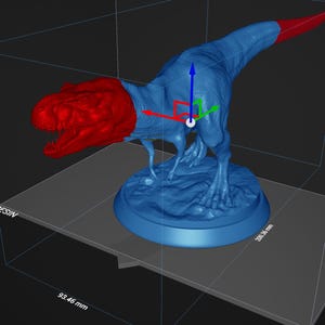 Puede incluir: Una figura de dinosaurio Tyrannosaurus Rex impresa en 3D, azul y roja, sobre una base azul. El dinosaurio est&aacute; en posici&oacute;n de caminar, con la boca abierta y la cola levantada. La base es redonda y tiene una superficie texturizada.