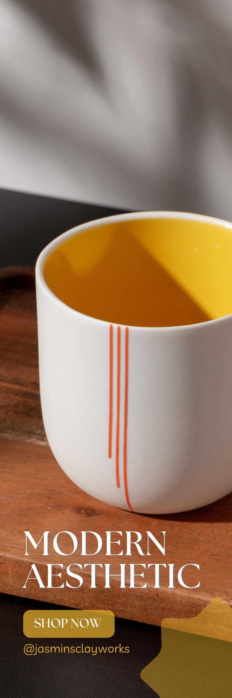 Peut inclure: Une tasse en c&eacute;ramique blanche avec un int&eacute;rieur jaune et trois fines lignes orange. La tasse est pos&eacute;e sur une surface en bois. Le texte "MODERN AESTHETIC" est sous la tasse. Le texte "SHOP NOW" et "@jasminsclayworks" sont sous le texte.