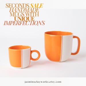 May include: Two handmade ceramic mugs with unique imperfections. The mugs are orange with a white stripe down the side. The larger mug has a rounded shape, while the smaller mug has a more traditional shape.  "Seconds Sale Handmade Mugs with Unique Imperfections" is written in orange text at the top of the image.