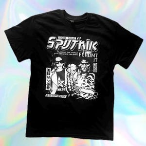 May include: Black t-shirt with a white graphic design. The design includes the word "Sputnik" in a stylized font, along with the phrases "Fleeing the World with Designer Violence" and "Fehunt It". The shirt also features a graphic of two people.